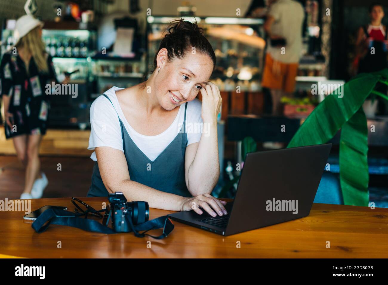 Nette Sommersprossen selbstbewusste Frau professionelle Arbeit auf Laptop im Café. Stockfoto