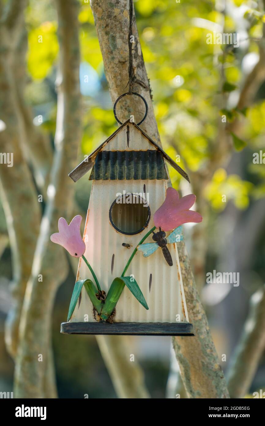 Nahaufnahme eines Vogelhauses mit rosa Blumen. Stockfoto