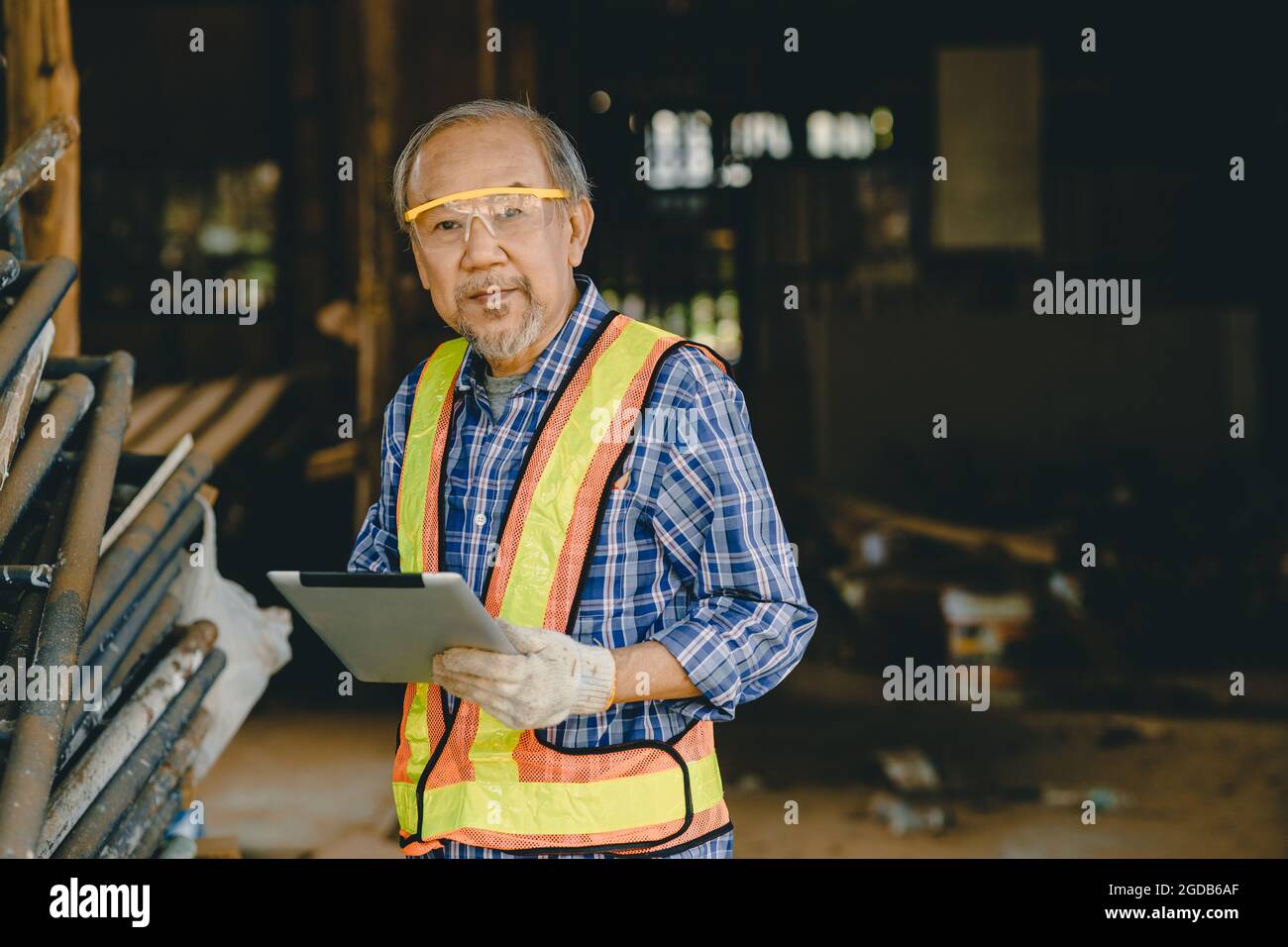 Portrait der ältere Ingenieur, der auf der Baustelle mit Tablet-Computertechnologie arbeitet, ist ein Vorarbeiter von Smart. Stockfoto