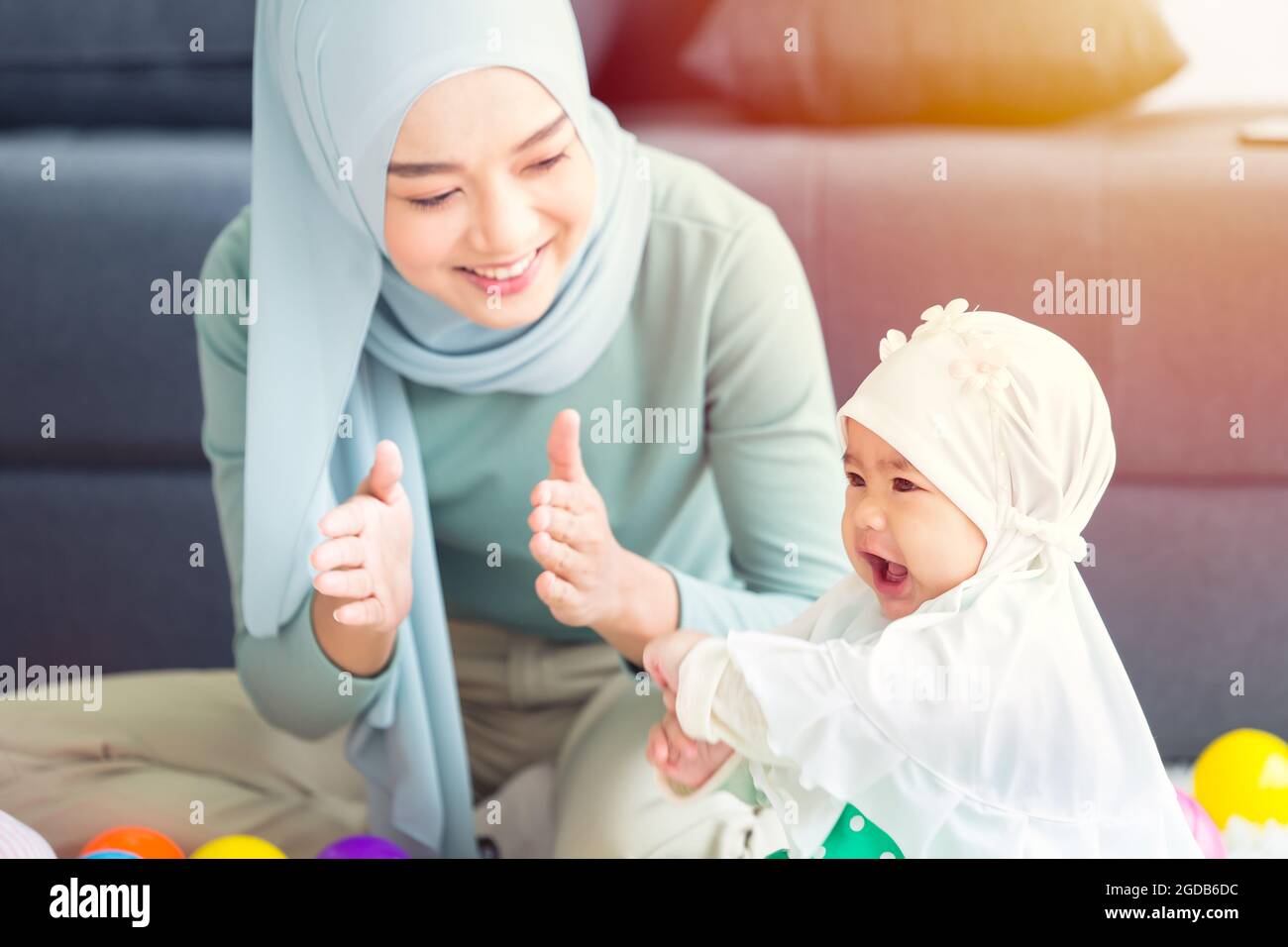 Muslim Mutter glücklich Lächeln genießen Sie spielen mit ihrem Baby Kinderbetreuung glücklich zusammen schönes Zuhause. Stockfoto