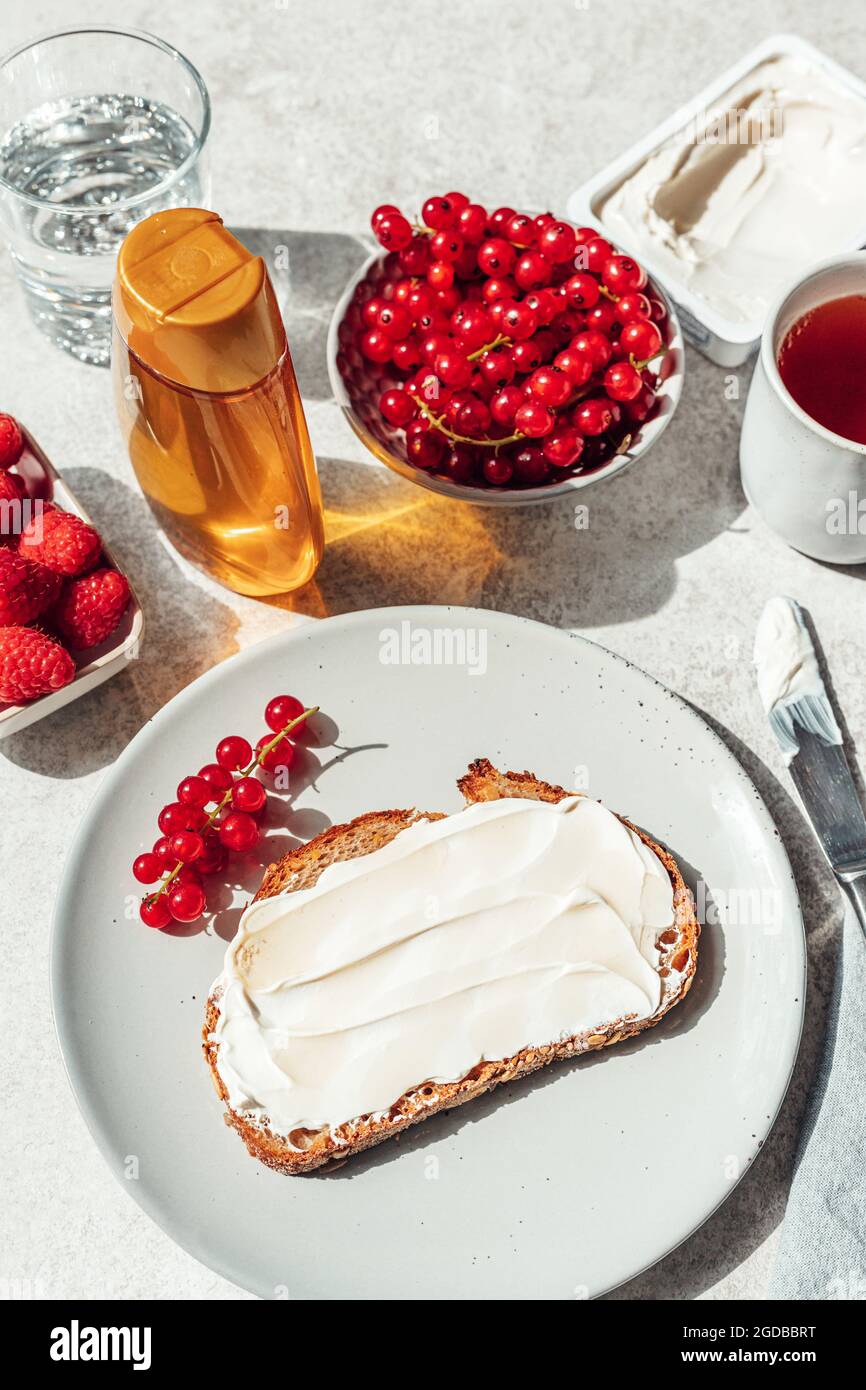 Brot mit Weichkäse und Honig darauf. Gesundes Frühstückskonzept. Stockfoto