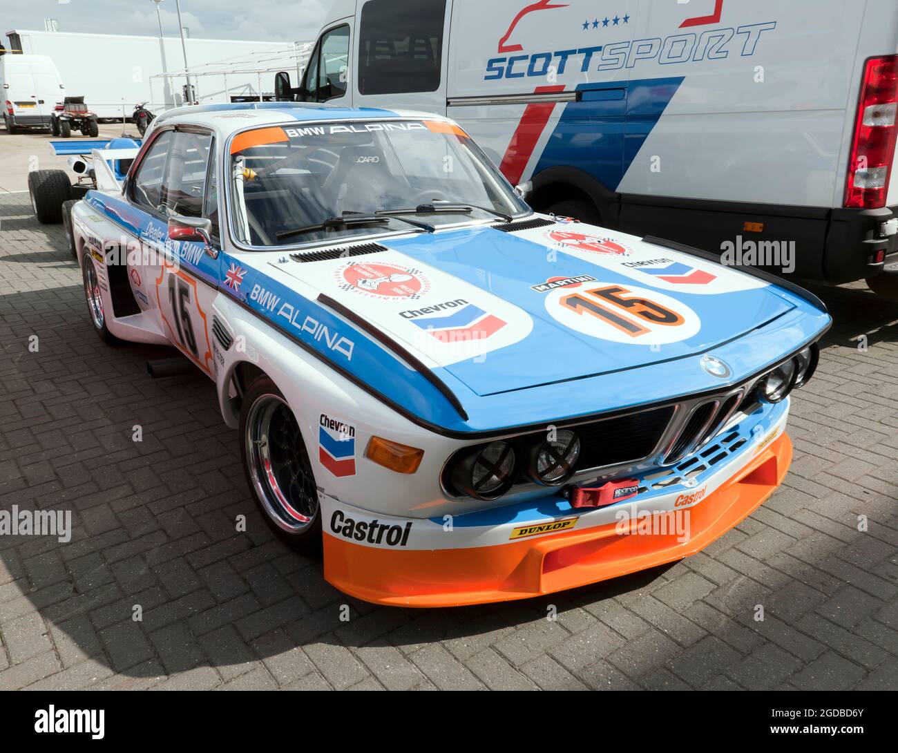 Drei Viertel Vorderansicht eines blau, weiß und orange BMW 3.0L CSL im International Paddock, während der Silverstone Classic 2021 Stockfoto