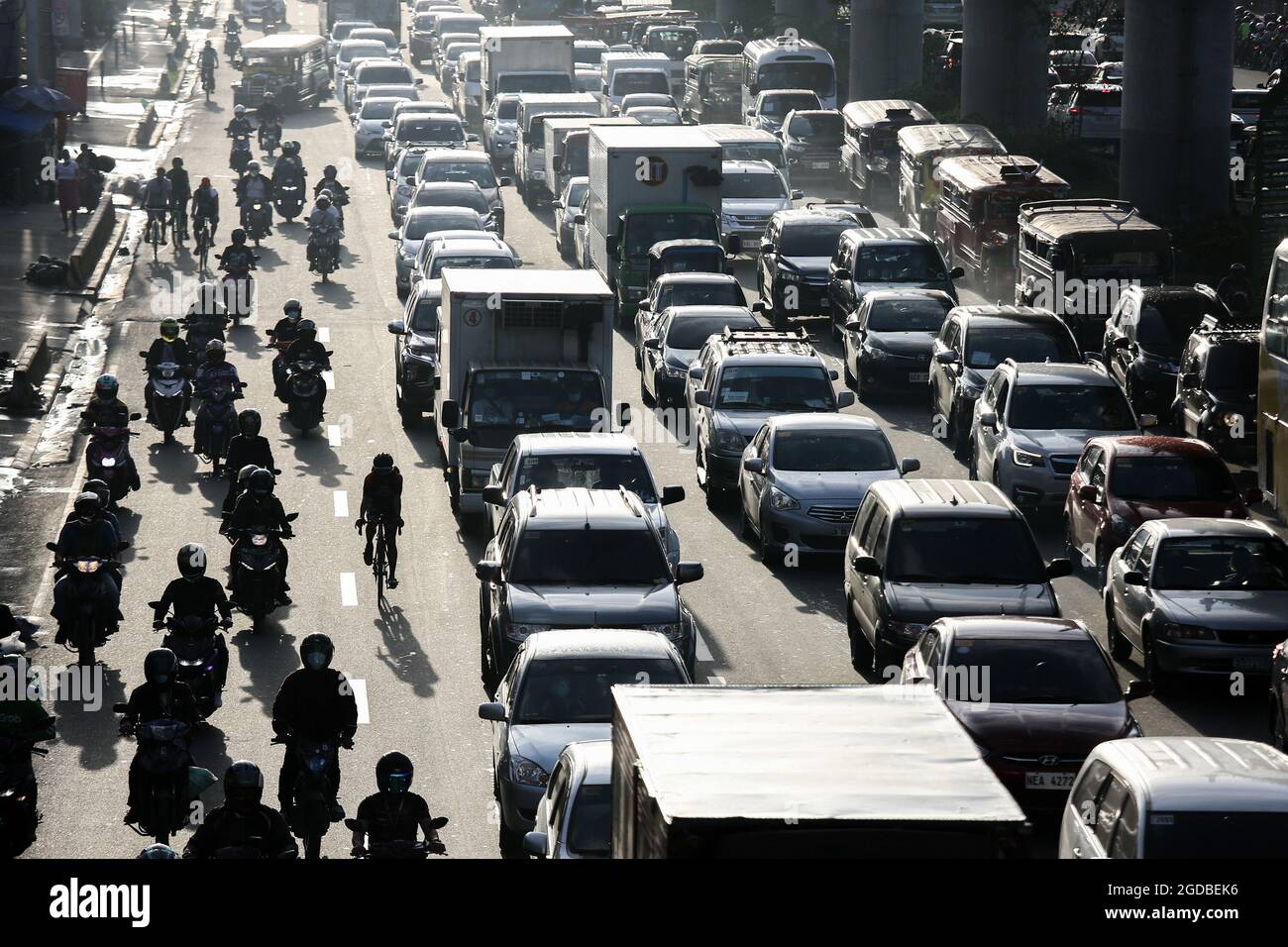 Polizisten mit Schutzausrüstung inspizieren Motorradfahrer an einem Kontrollpunkt während einer strengeren Sperre als Vorsichtsmaßnahme gegen die Ausbreitung der neuen Coronavirus-Krankheit am Stadtrand von Marikina City, Philippinen. Stockfoto