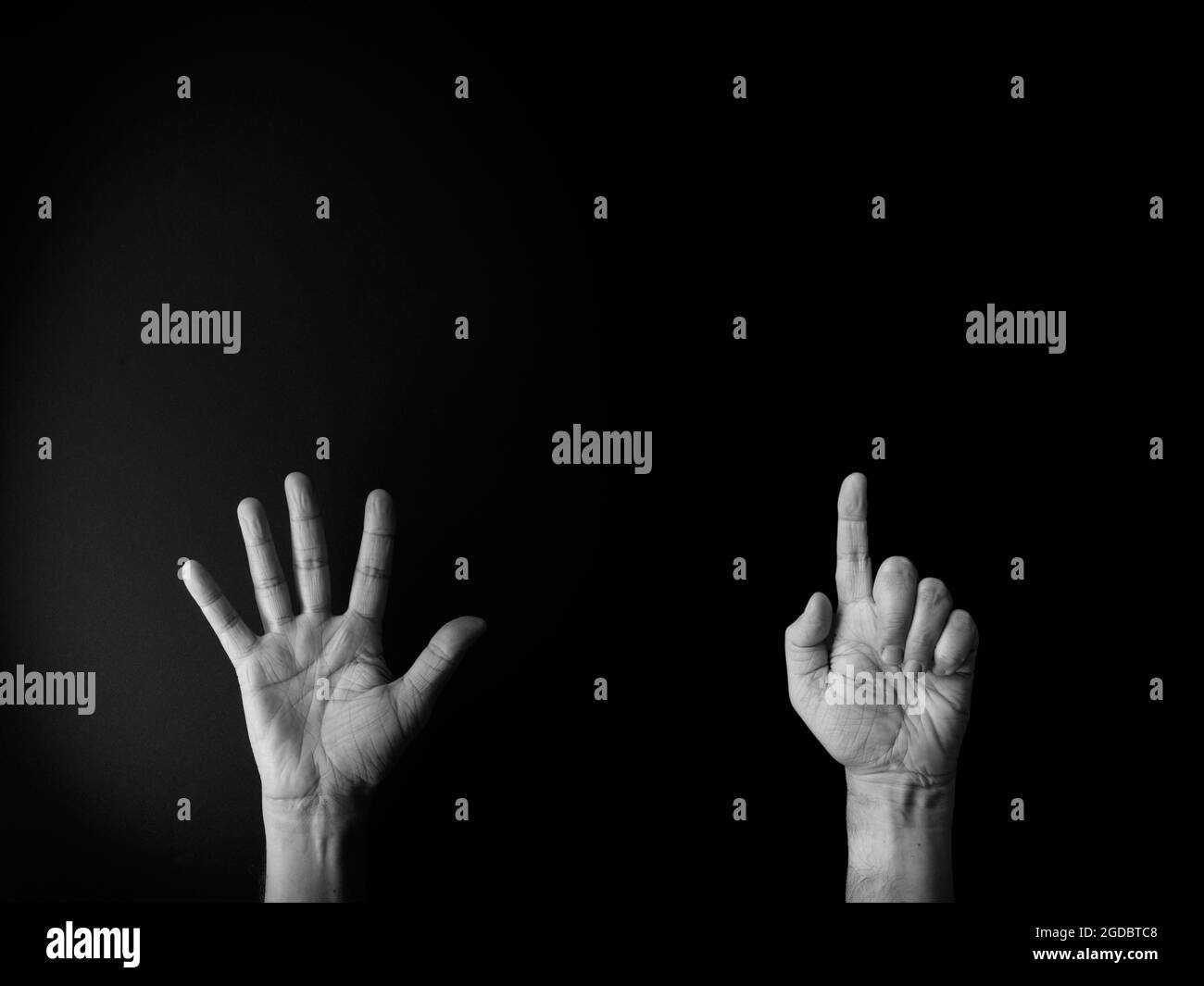 Dramatisches Schwarz-Weiß-Bild von männlicher Hand, das die Zeichensprache Nummer sechs vor schwarzem Hintergrund mit leerem Kopieplatz für Redakteure zeigt Stockfoto