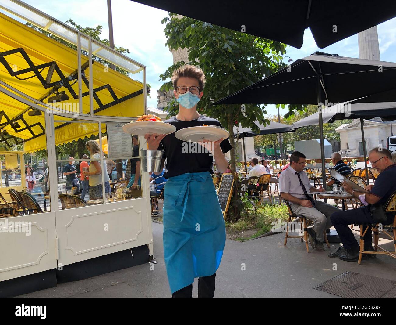 Paris, Frankreich, Teenager-Kellner mit COVID-Maske, arbeitet im französischen Bistro Restaurant, 'Chez Prosper' hält Teller draußen auf der Terrasse, modernes Restaurant paris Café Teller Stockfoto