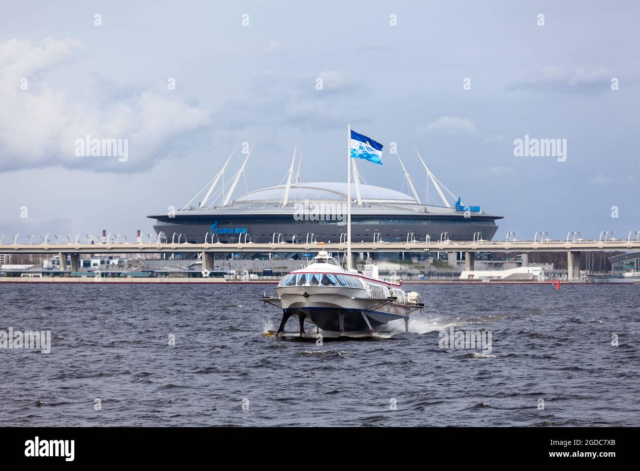 Sankt Petersburg, Russland-ca. Mai 2021: Ein Tragflächenboot befindet sich im Finnischen Meerbusen vor dem Fußballstadion der Gazprom Arena. Es befindet sich auf Stockfoto