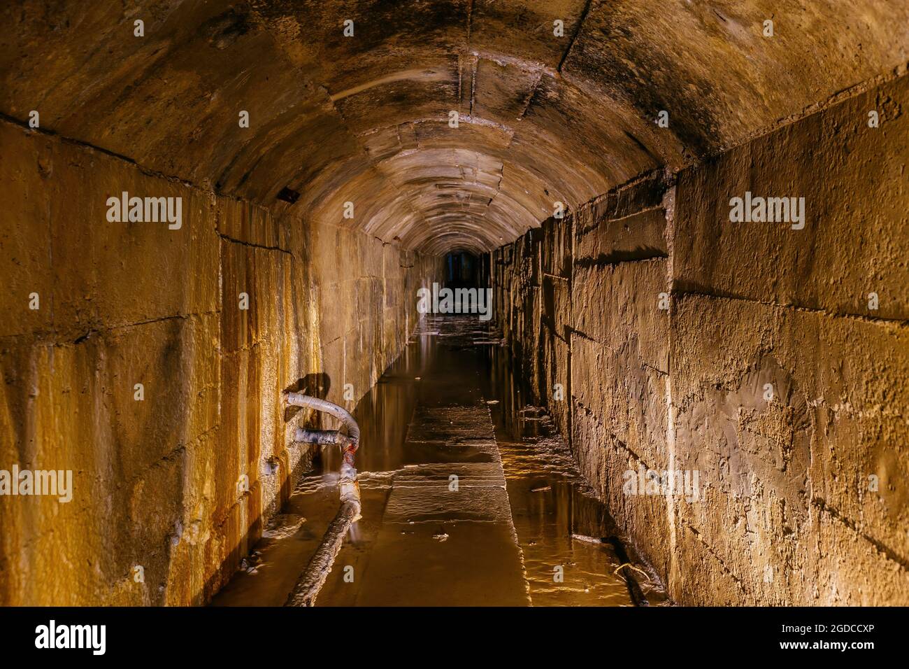 Alter dunkler gewölbter unterirdischer, überfluteter Kanaltunnel. Stockfoto