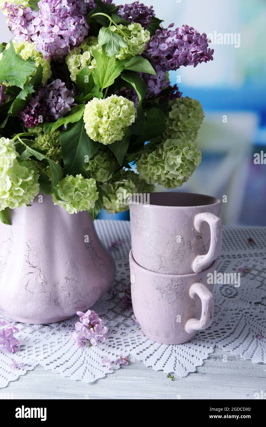 Zusammensetzung mit Tee Tassen und schöner Frühling Blumen in der Vase, auf  Holztisch, auf hellen Hintergrund Stockfotografie - Alamy