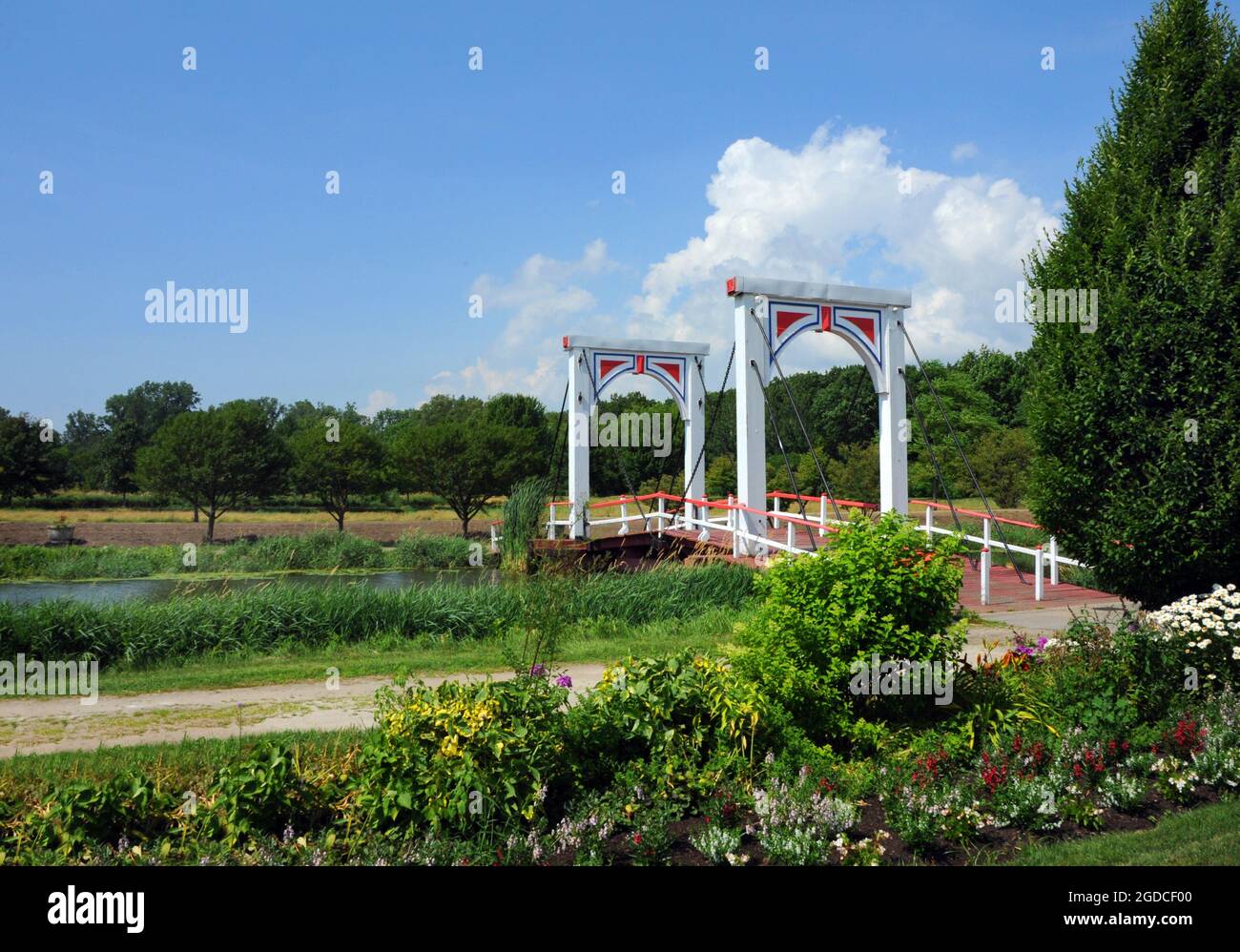 Die Fußgängerbrücke im holländischen Stil überspannt den Macatawa River in Dutch Island Gardens, Holland, Michigan. Brücke ist weiß mit blauem Rand. Stockfoto