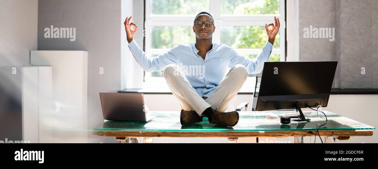 Afrikanischer Mitarbeiter, Der Im Büro Eine Yoga-Meditation Für Psychische Gesundheit Macht Stockfoto