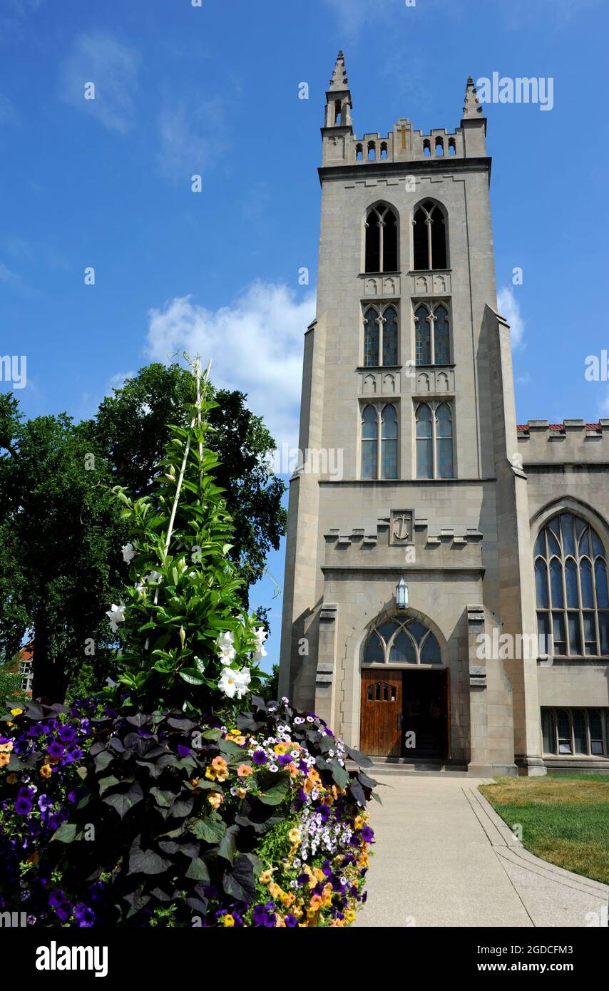 Wunderschöne Blumen vom Eingang zur Kapelle am Hope College in Holland, Michigan. Blauer Himmel umrahmt auch die Kapelle. Stockfoto