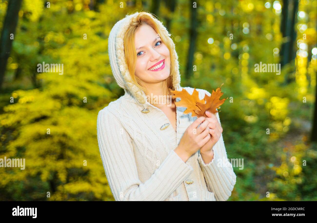Schönes Mädchen zu Fuß im Herbst Park. Lächelnde Frau mit gelben Blättern. Weibchen genießen Herbstwetter. Sonniger Tag. Stockfoto