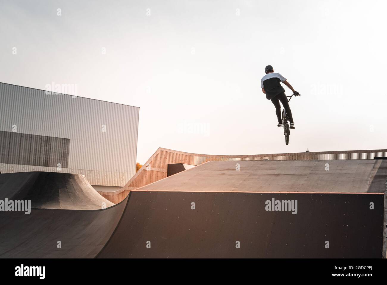 Ein junger Fahrer auf einem BMX-Fahrrad macht Tricks in der Luft. BMX Freestyle in einem Skatepark. Stockfoto