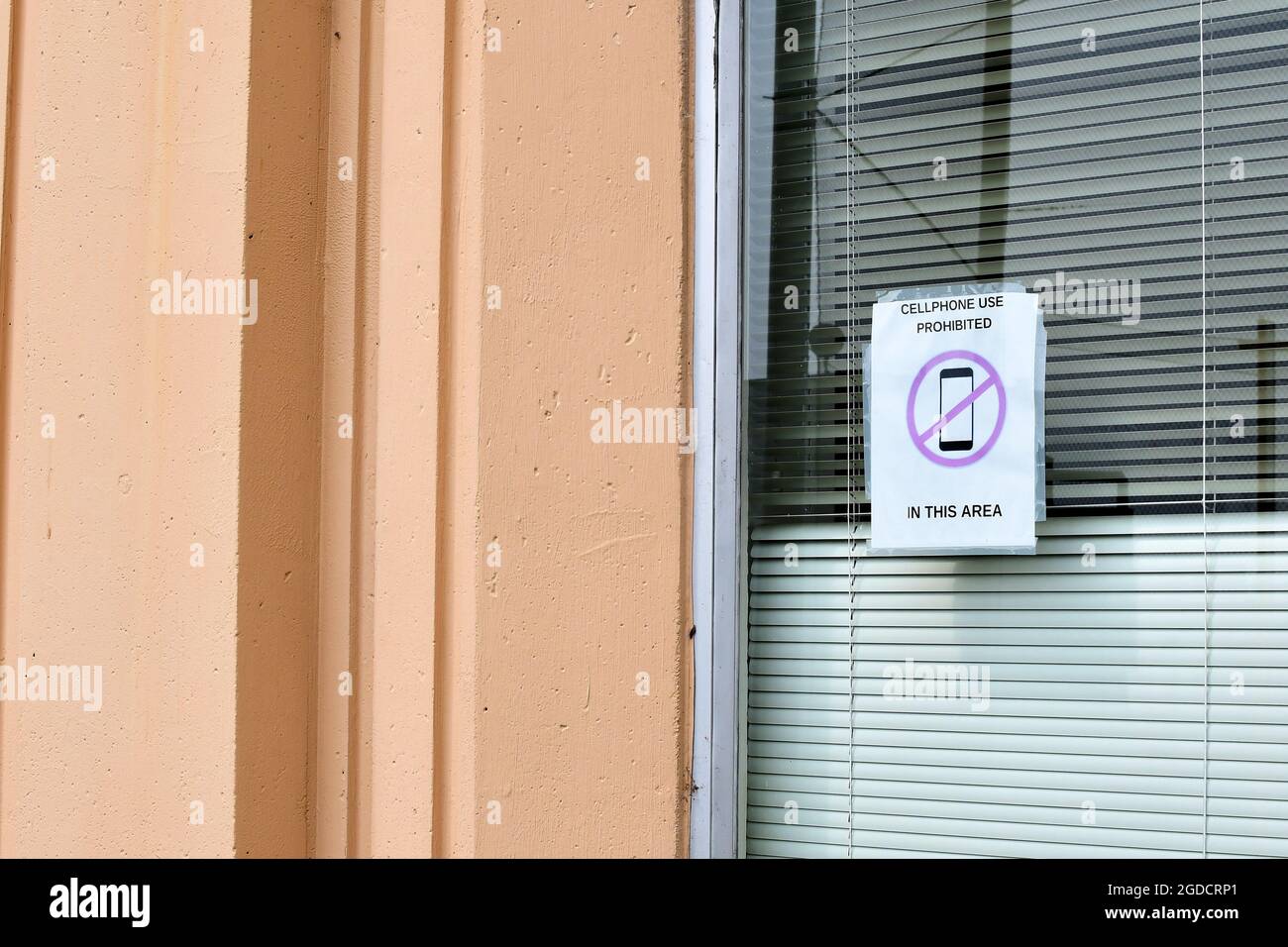 Aufgedrucktes Schild auf Glasfenster, das darauf hinweist, dass es sich um eine Handyfreizone handelt; Handynutzung ist eingeschränkt und verboten; San Francisco, Kalifornien. Stockfoto