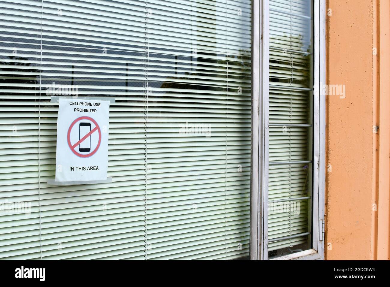 Aufgedrucktes Schild auf Glasfenster, das darauf hinweist, dass es sich um eine Handyfreizone handelt; Handynutzung ist eingeschränkt und verboten; San Francisco, Kalifornien. Stockfoto