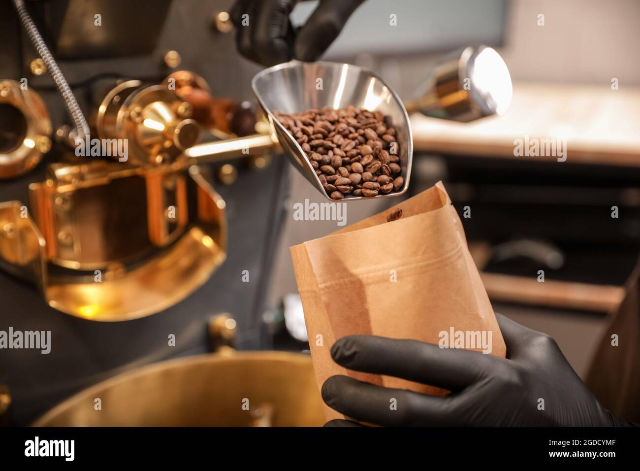 Mann verpackt Kaffeebohnen nach dem Rösten Stockfoto