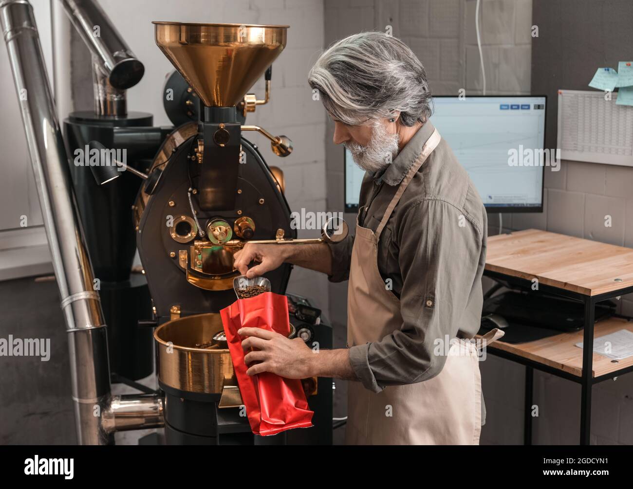 Leitender Mann verpackt Kaffeebohnen nach dem Rösten Stockfoto