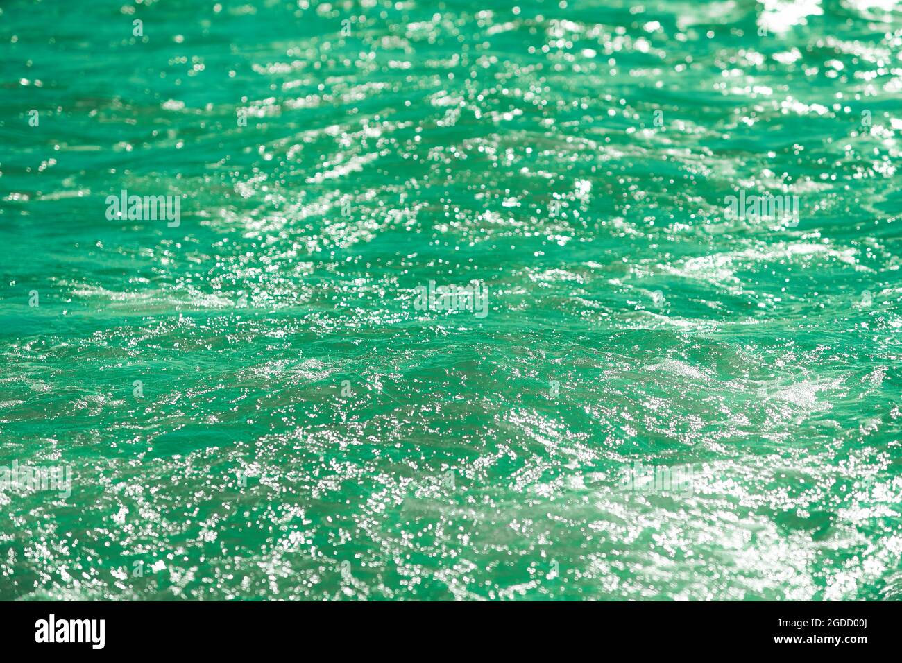 Detail eines Sonnenlichts, das im glitzernden Meer reflektiert wird. Funkelt im Wasser - Hintergrund. Meerwasser mit Sonnenblendung und Welligkeit. Kraftvolle und friedliche Natur c Stockfoto
