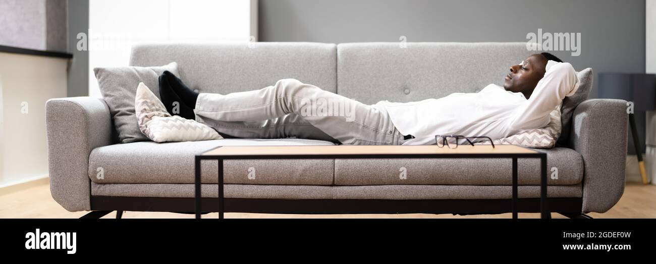 Happy Man Entspannt Sich Auf Dem Sofa Oder Der Couch Stockfoto