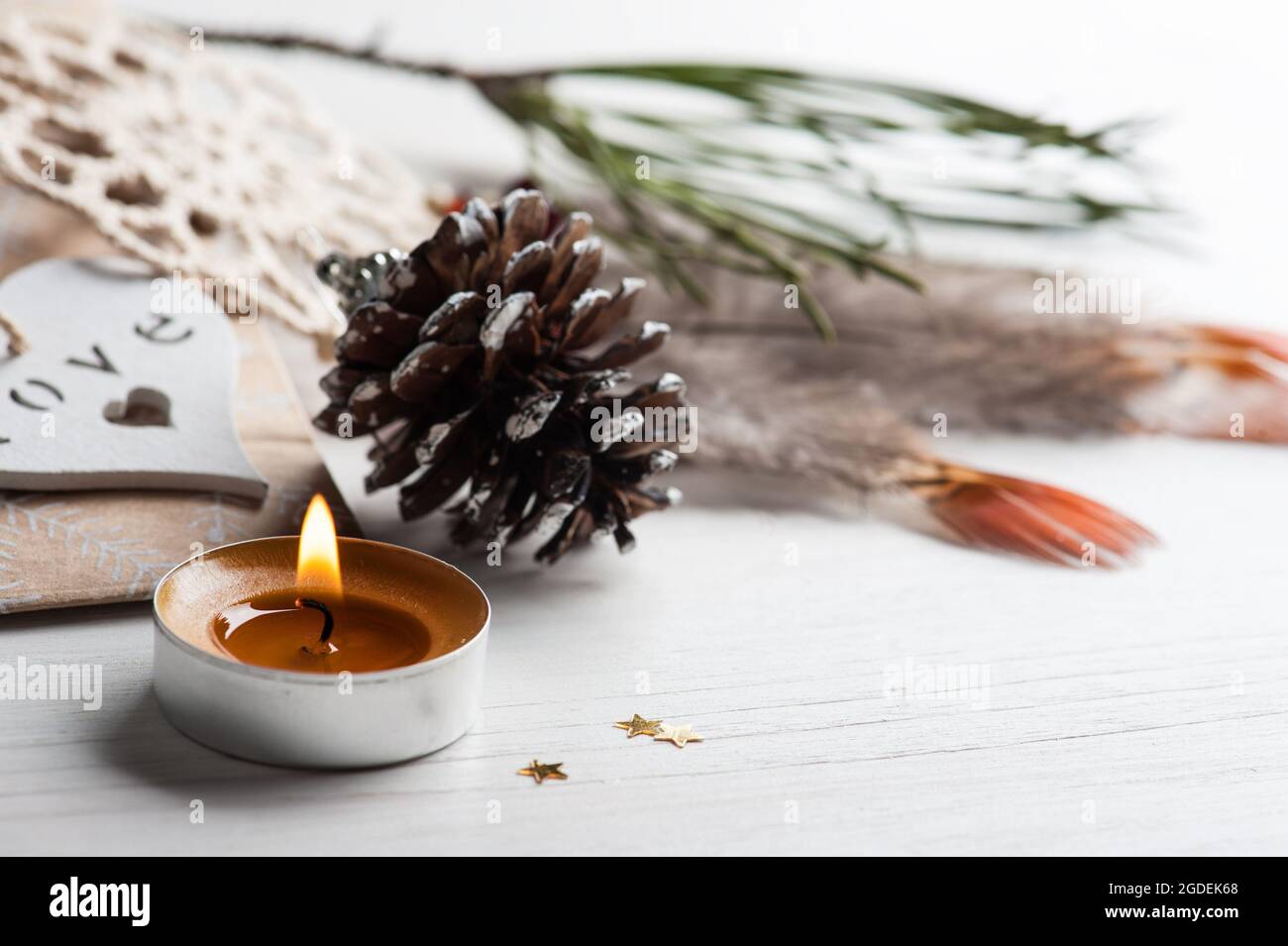 Geschenk Kraftbeutel und beige Traumfänger, Kerze angezündet, Pinienzapfen. Valentinstag-, weihnachts- oder Geburtstagskonzept im skandinavischen Stil mit Copyspace Stockfoto