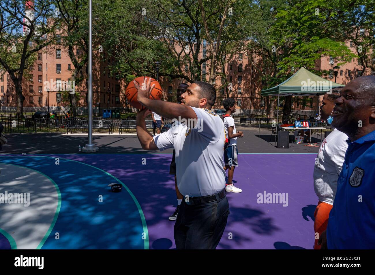 New York, Usa. August 2021. Bei einer Eröffnungsveranstaltung des Queensbridge Houses Basketball Court im Queens Borough of New York City spielen Menschen Basketball.die New Yorker Polizeibehörde renoviert den Basketballplatz an den NYCHA Queensbridge Houses durch die Verwendung von Vergeltermitteln. Es ist einer von 15 Basketballplätzen in der ganzen Stadt, die von der NYPD renoviert werden. Das 4 Millionen-Millionen-Projekt wird aus Drogenbusten finanziert. (Foto von Ron Adar/SOPA Images/Sipa USA) Quelle: SIPA USA/Alamy Live News Stockfoto