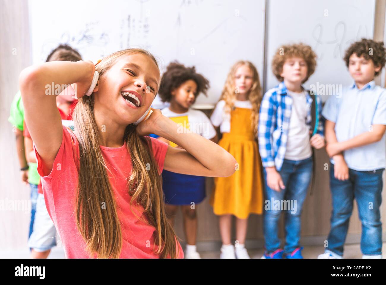 Multirassische Gruppe von Kindern in der Grundschule - spielerische Schüler genießen Schulzeit und Unterricht mit Lehrer und Klassenkameraden Stockfoto