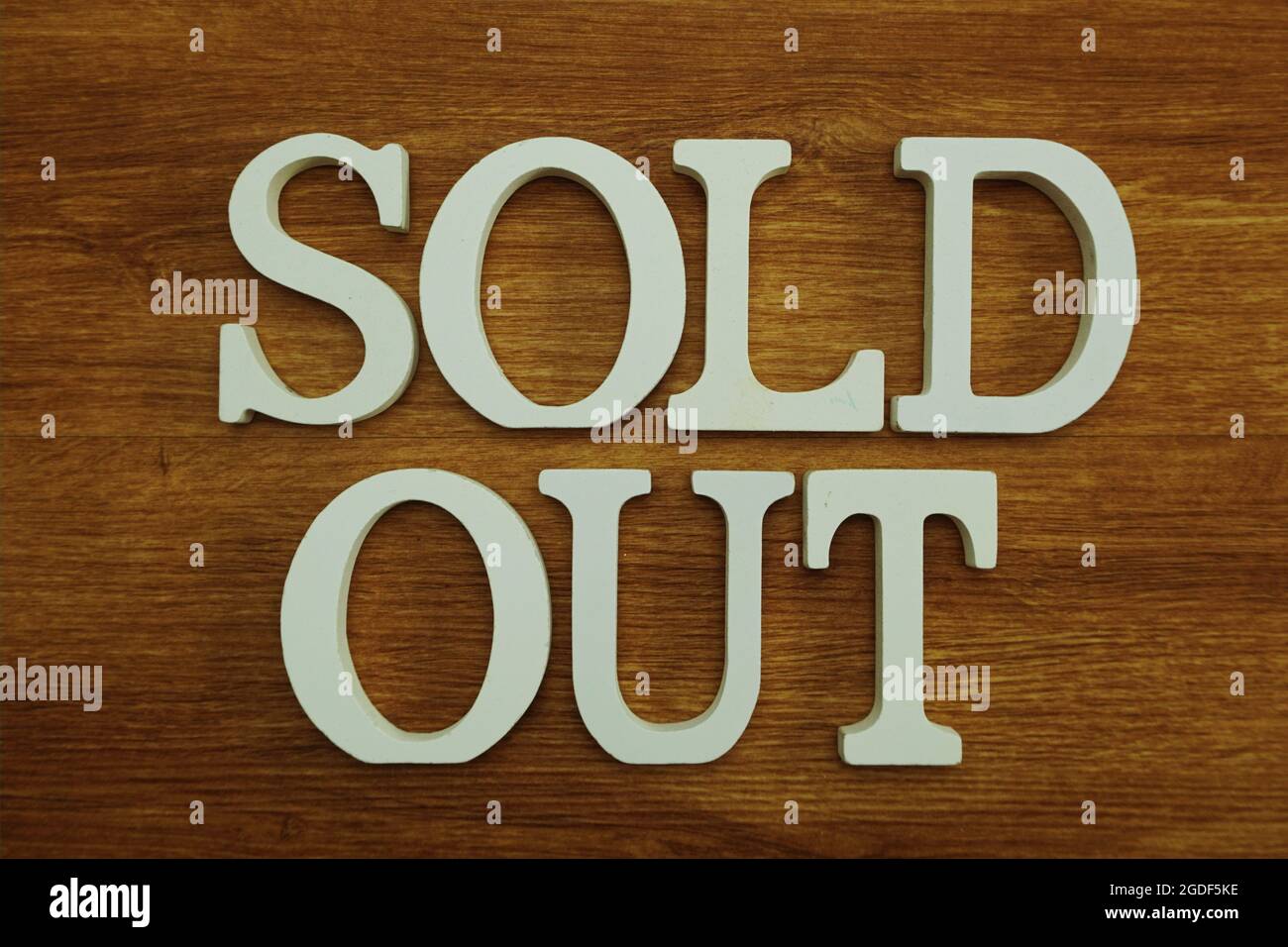 Ausverkaufte Buchstaben auf Holzhintergrund Stockfoto