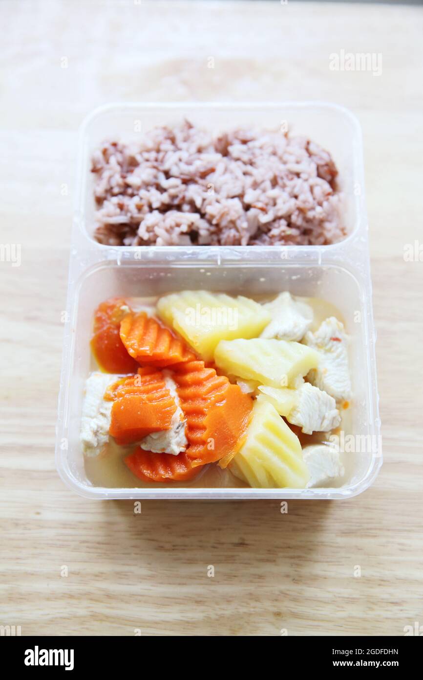 Saubere Lebensmittel Dampfgaren Sie Kartoffel-Hühnerkarotte mit Reis in Bento Stockfoto