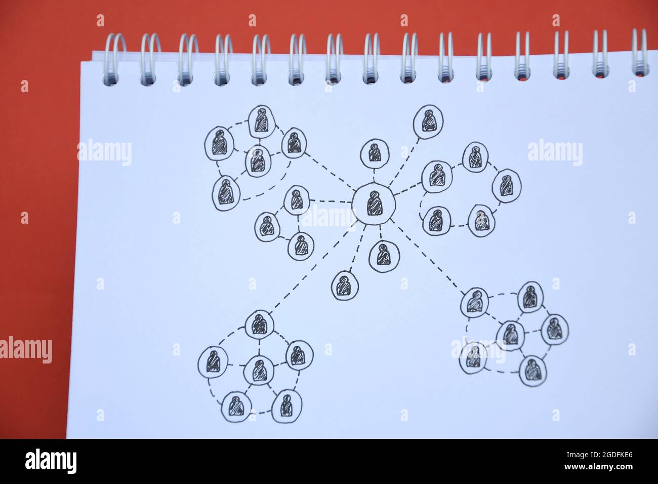 Foto einer Zeichnung eines sozialen Netzwerks auf einem Notizbuch auf rotem Hintergrund Stockfoto