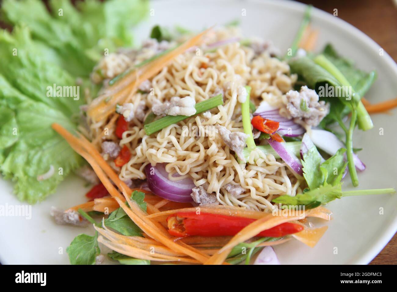 Thai-Salat mit Karotten, Tomaten, Glasnudeln, Sellerie und Schweinefleisch Stockfoto