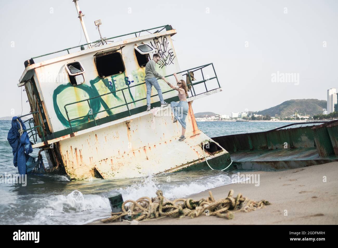 Junge Liebespaar haben Spaß im Urlaub. Grunge-Stil. Altes Boot am Meer. Meerblick. Hochwertige Fotos Stockfoto