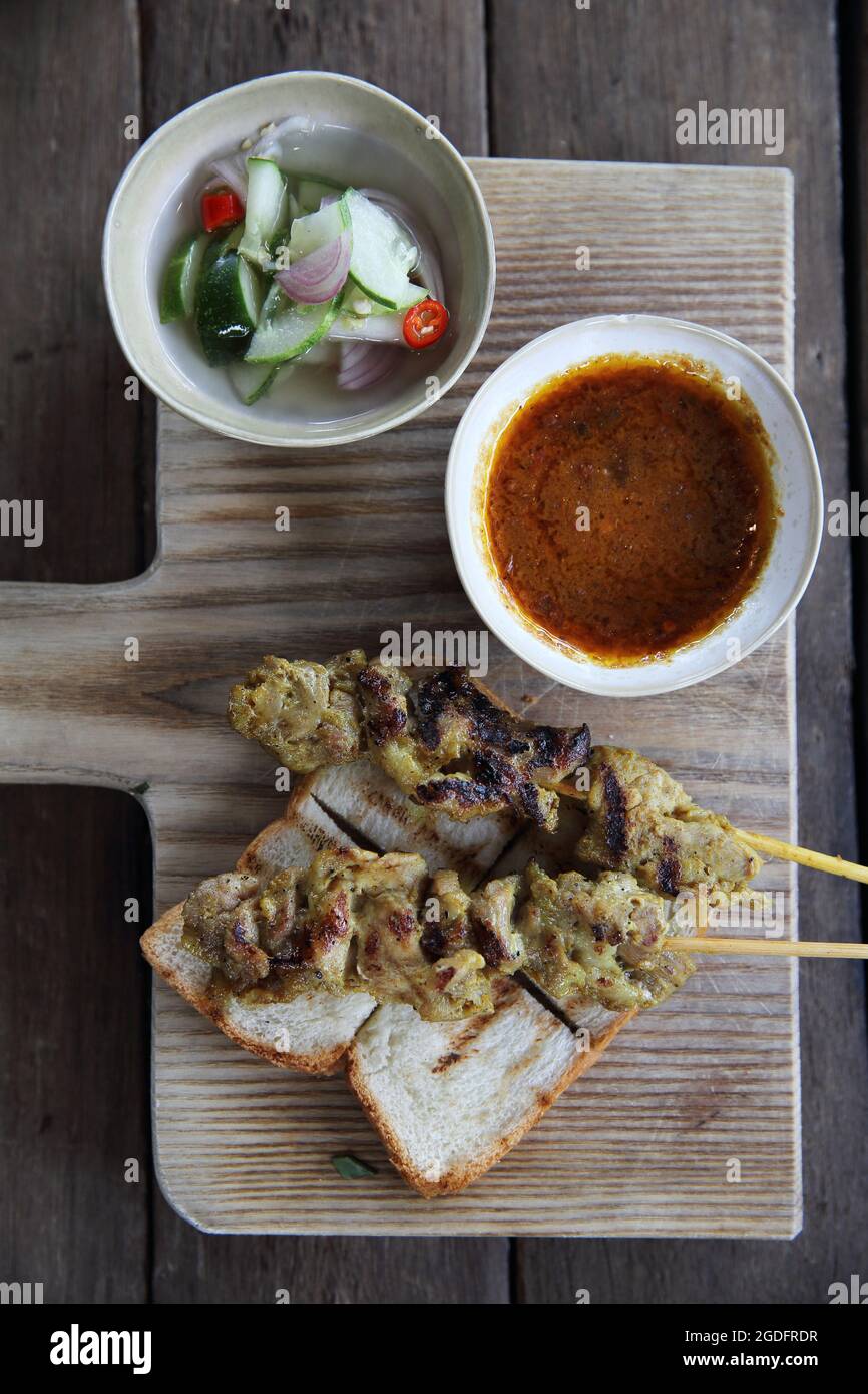 Malaysisches Essen Hähnchensatay mit Erdnusssauce auf Holzhintergrund Stockfoto