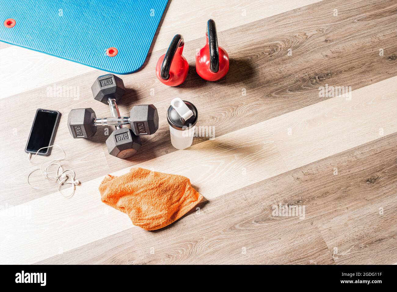 Draufsicht Kettlebells, foar Roller, Kurzhanteln, eine Flasche, ein Handtuch und ein Handy Stockfoto