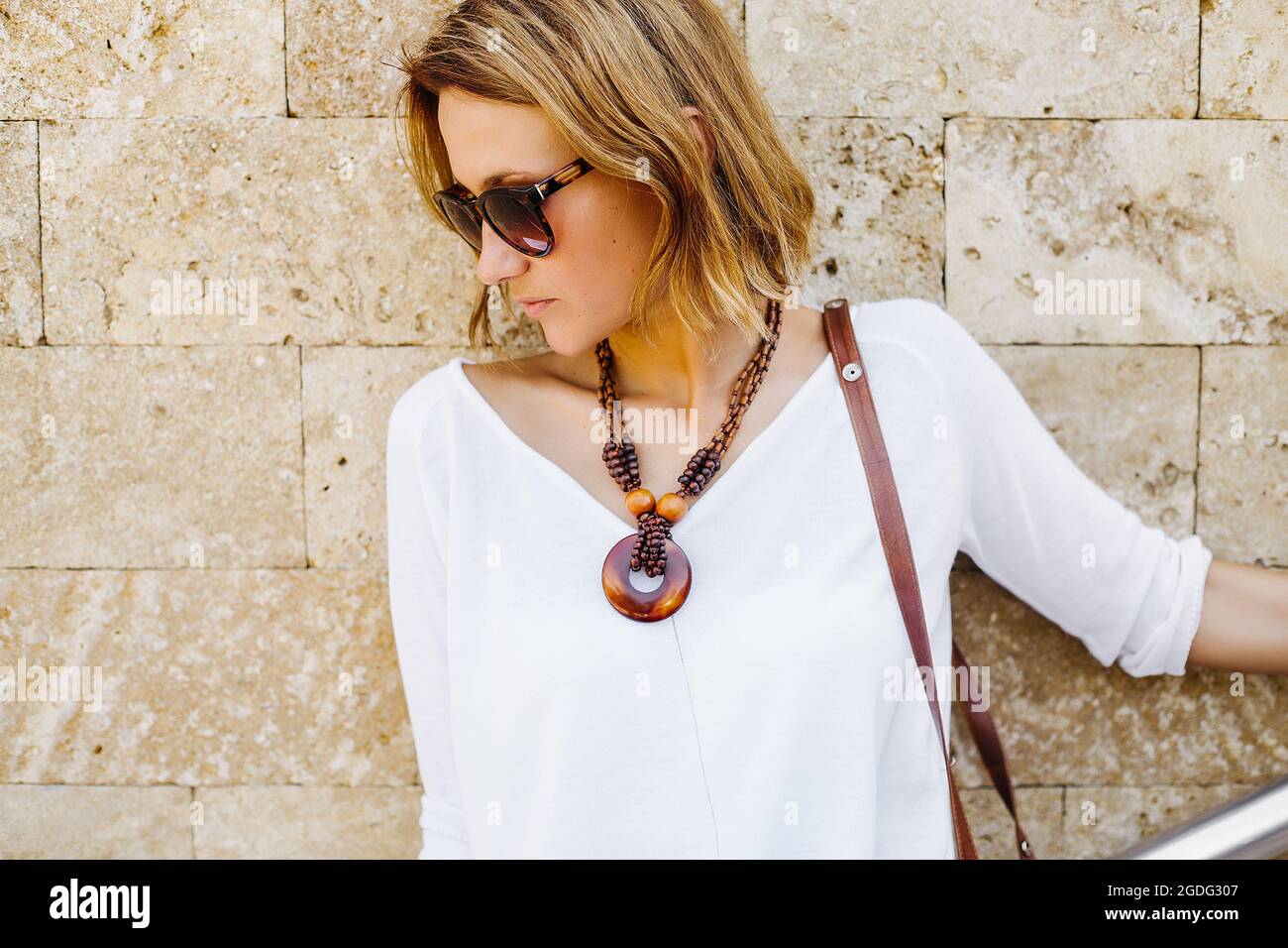 Frau lehnte sich gegen die Mauer aus Stein Stockfoto