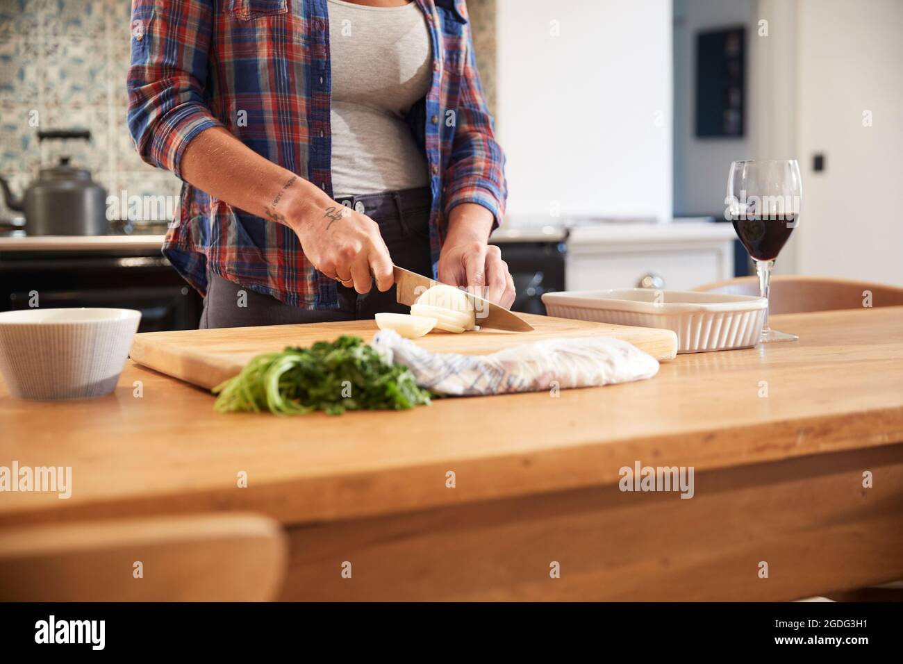 Frau schneiden Zwiebel am Küchentisch, mittlerer Abschnitt Stockfoto