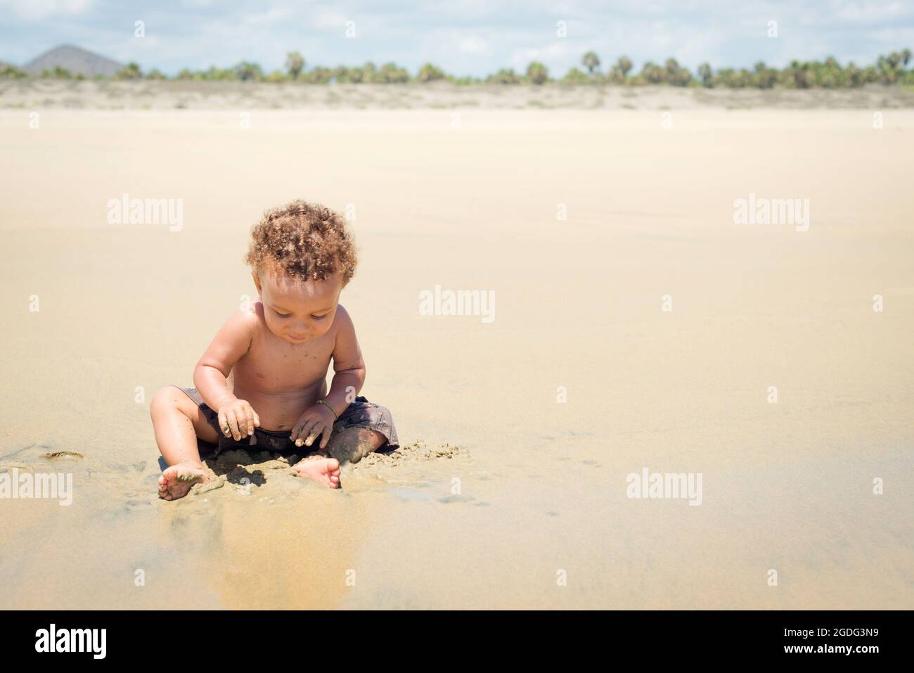 Kleinkind spielen im Sand am Strand Stockfoto