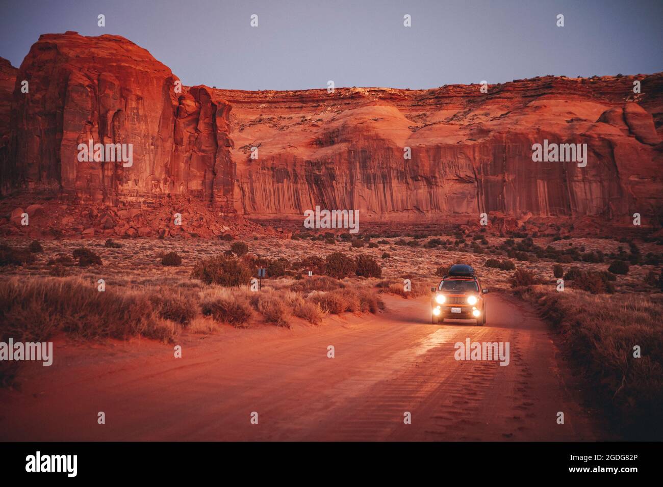 Ein Auto ist auf der Straße mitten im Monument Valley, Arizona, USA Stockfoto
