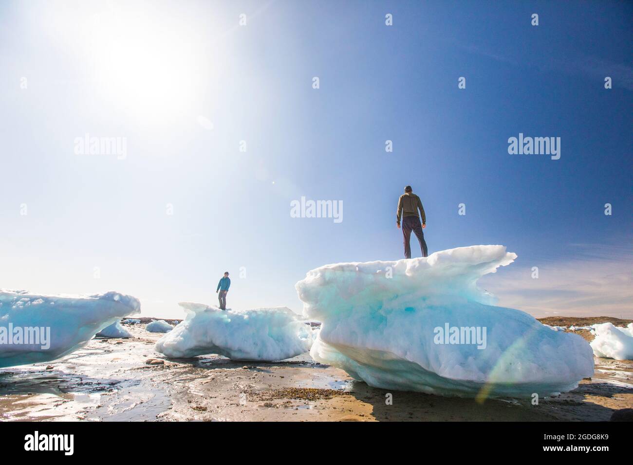 Zwei Männer, die auf Meereisbrocken stehen, Iqaluit, Kanada. Stockfoto