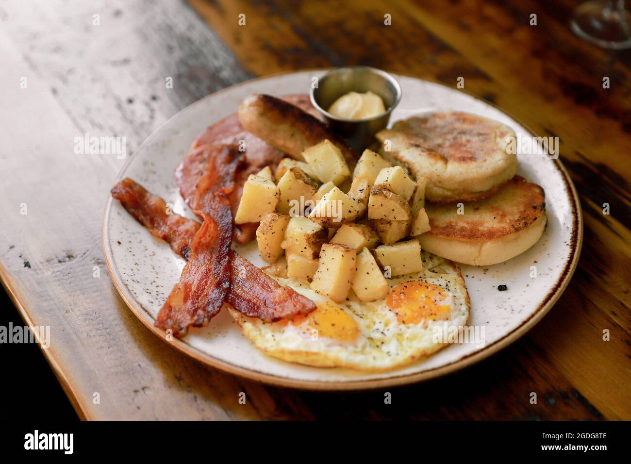 Frühstücksteller mit Wurst, Kartoffeln, Speck und Eiern Stockfoto