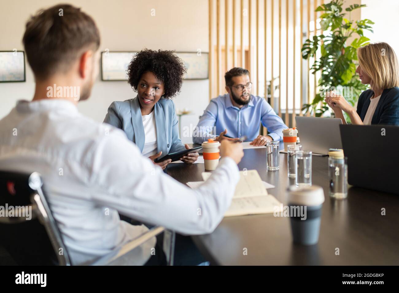 Schwarzer Chef diskutiert Geschäftsprojekt mit Mitarbeitern während des Seminars im Büro Stockfoto