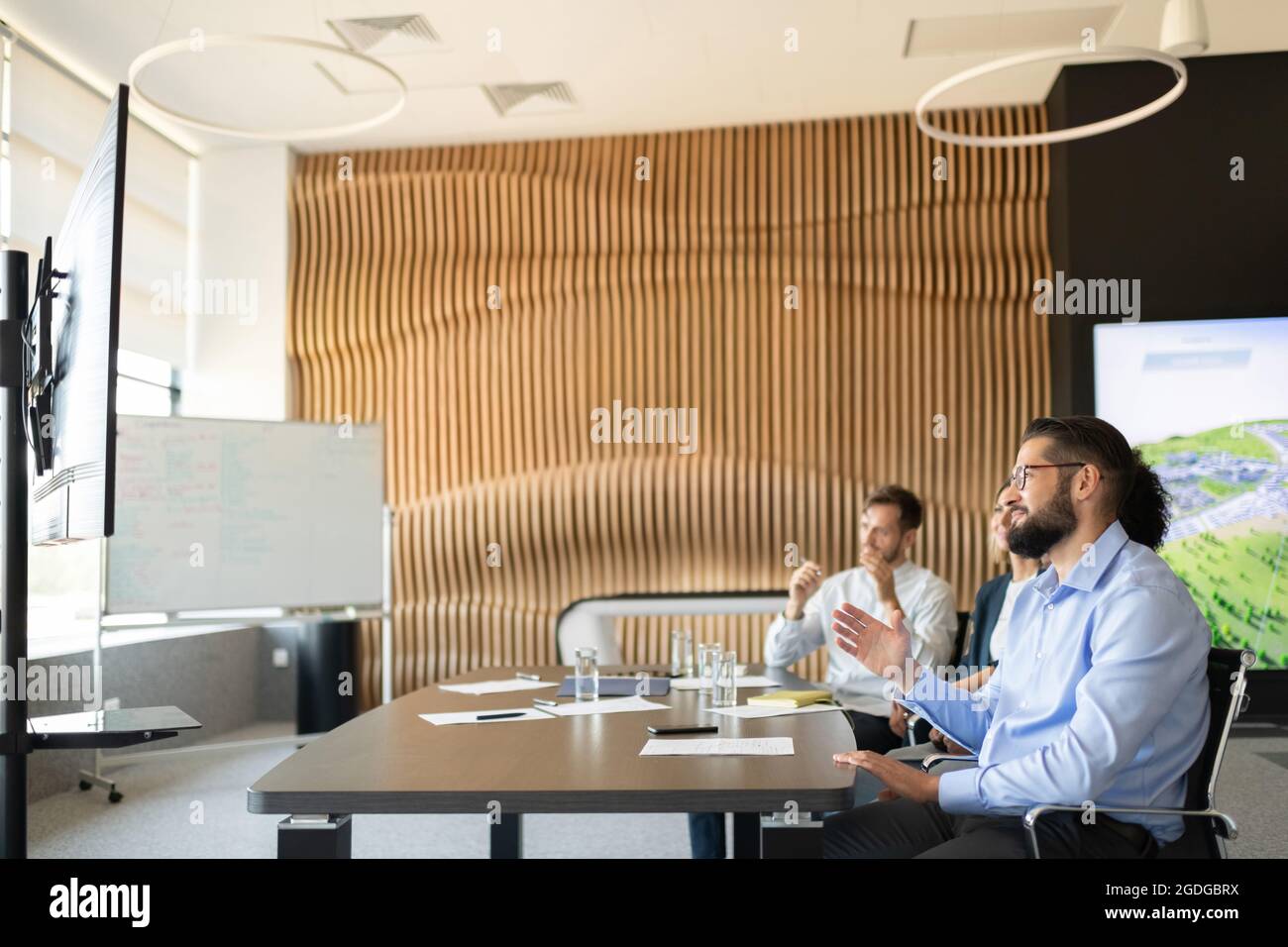 Büromitarbeiter sitzen am Tisch und diskutieren während eines virtuellen Meetings über Geschäfte Stockfoto