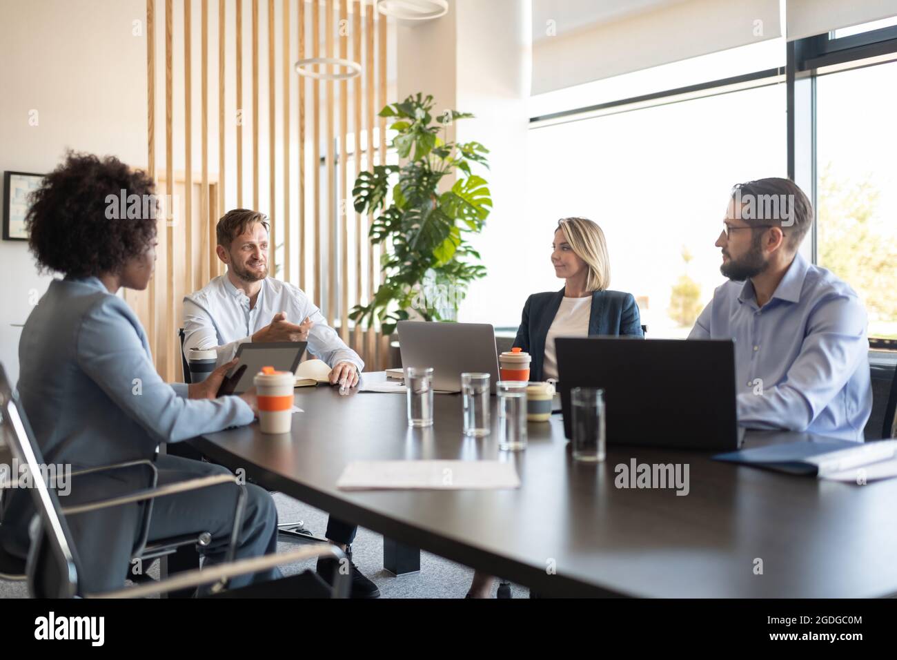 Bärtiger Chef plant Geschäftsstrategie mit multirassischen Arbeitnehmern während des Treffens Stockfoto