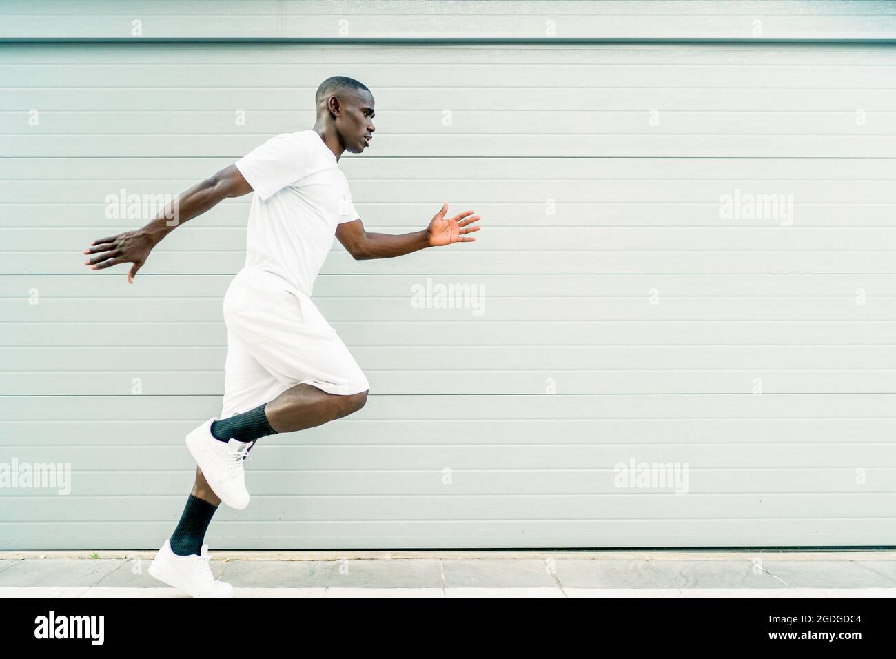 Junger afrikanischer Mann trainiert seine Lauftechnik Stockfoto
