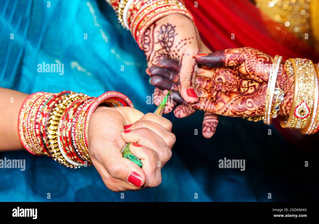 Künstler, die Anwendung von Henna-Tattoo auf Frauen Hände. Mehndi ist die traditionelle indische dekorative Kunst. Close-up Stockfoto