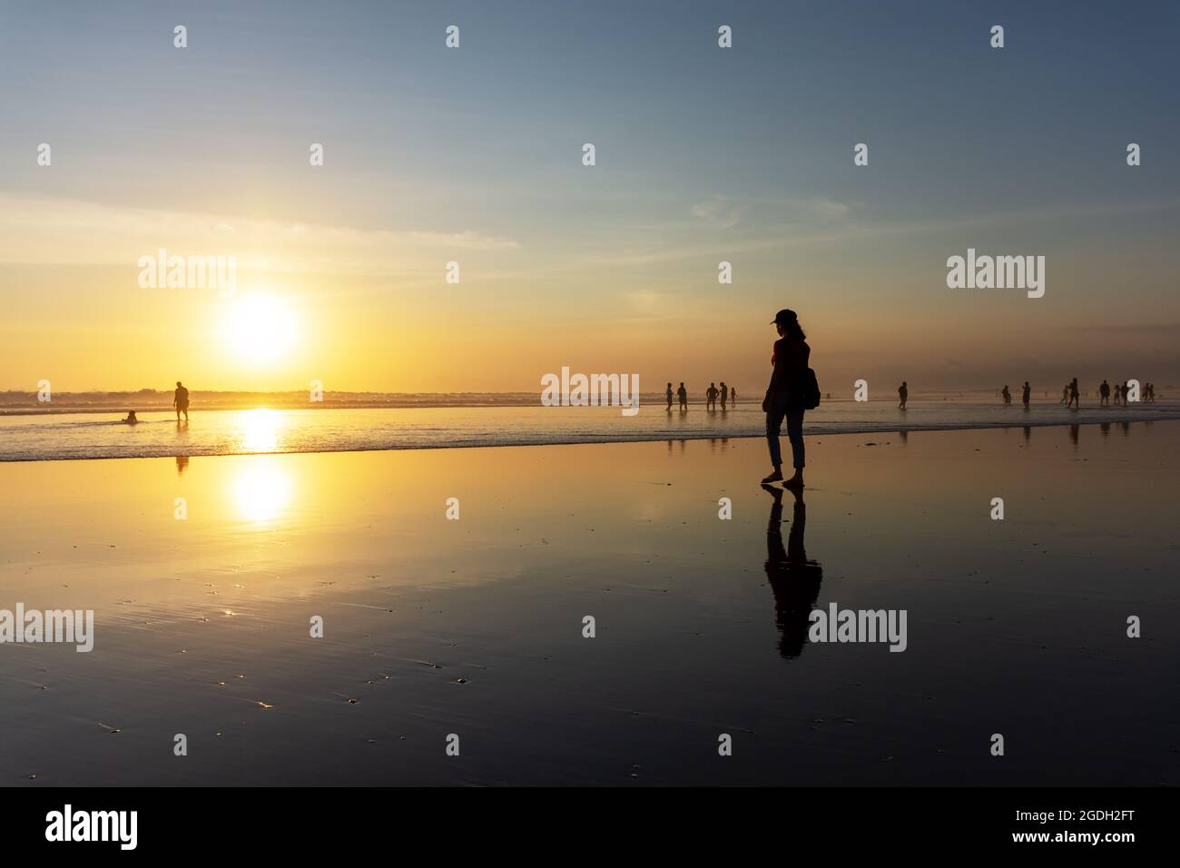 Kuta, Indonesien - 14. September 2018: Silhouette einer Frau, die am Seminyak-Strand auf Bali spazieren und den Sonnenuntergang genießen kann. Es ist eine der Touristenattraktionen in Stockfoto