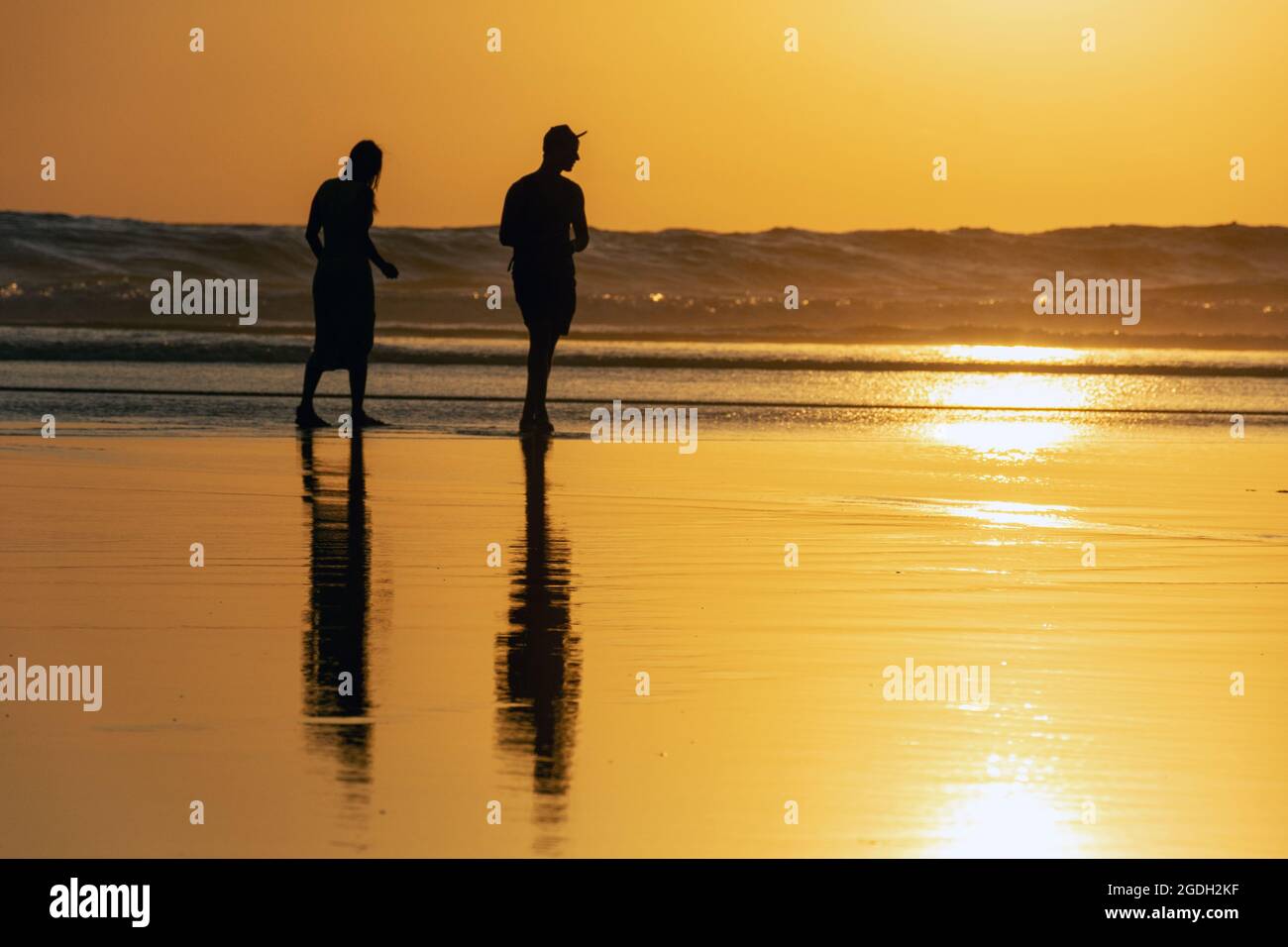 Kuta, Indonesien - 14. September 2018: Menschen, die am Seminyak-Strand auf Bali spazieren und den Sonnenuntergang genießen. Es ist eine der Touristenattraktionen in dieser Gegend. Stockfoto