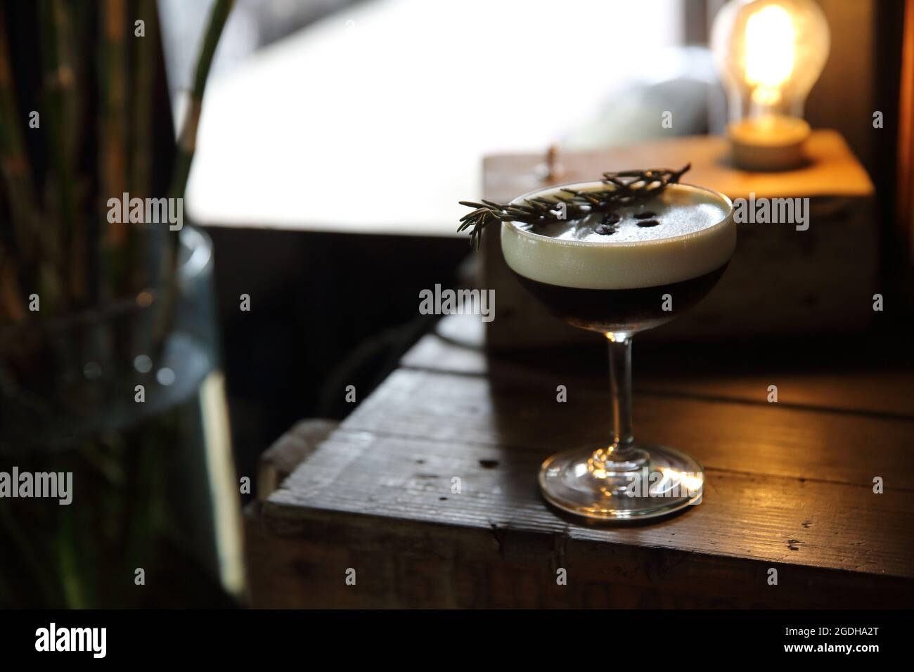 Kaffeecocktail mit Kaffeebohne und Rosmarin auf der Oberseite mit Holzhintergrund Stockfoto