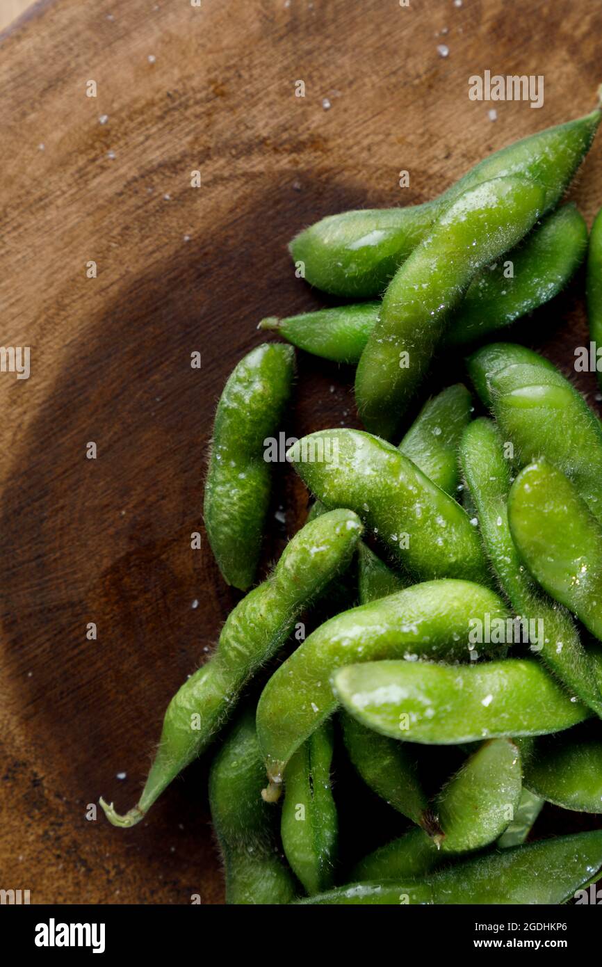 Grüner Edamame mit Salz auf Holzplette Stockfoto