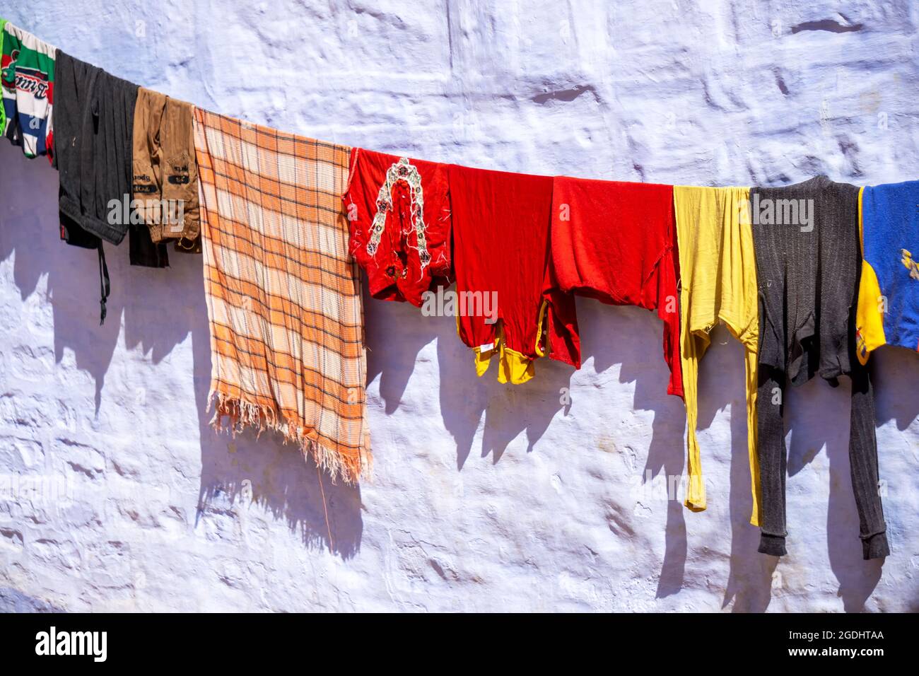 Farbenfrohe Kleidung, die in Indien gegen die Mauer trocknend ist Stockfoto