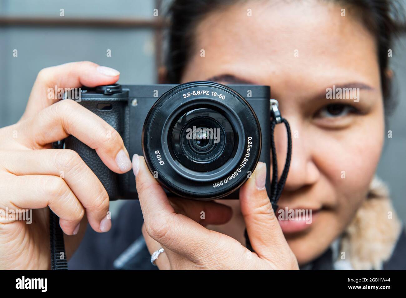 Frau, die ein Foto mit einer spiegellosen digitalen Kamera gemacht hat Stockfoto